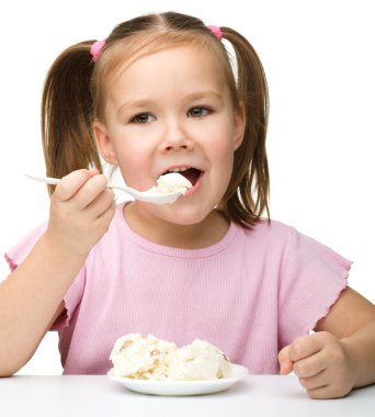 Cute little girl is eating cottage cheese clipart