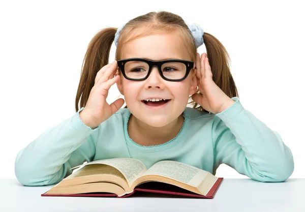 Kislány elolvassa a könyvet szemüveg viselése — Stock Fotó