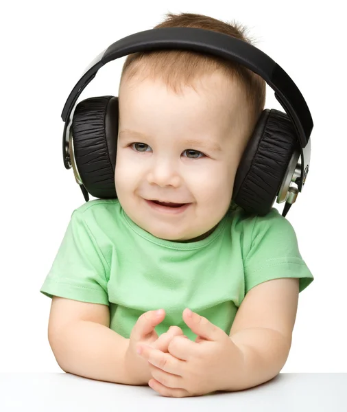 Lindo chico disfrutando de la música usando auriculares —  Fotos de Stock