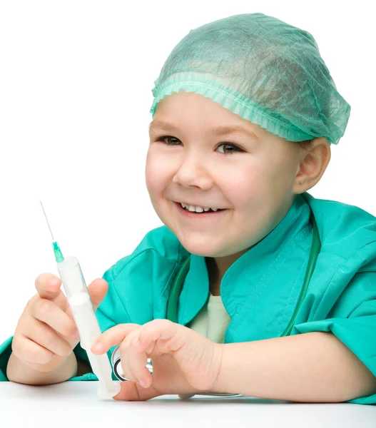 Sevimli küçük kız doktor şırınga ile oynuyor — Stok fotoğraf