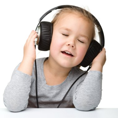 Kulaklık takıp müzik dinlemekten hoşlanan tatlı küçük kız.