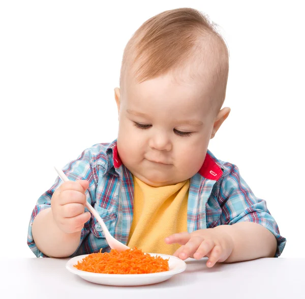Cute little boy is playing with carrot salad — Stock Photo, Image
