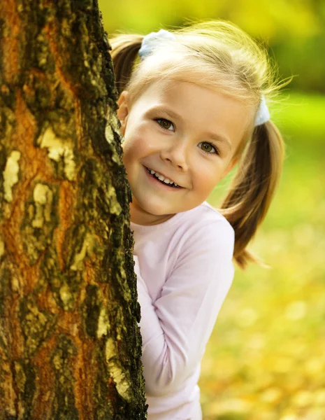 Schattig klein meisje is spelen verstoppertje en zoeken — Stockfoto