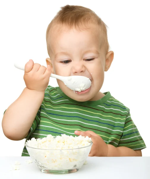 Cute little boy is eating cottage cheese — Stock Photo, Image
