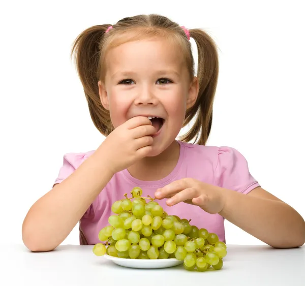 Little girl is eating grapes — Stock Photo, Image