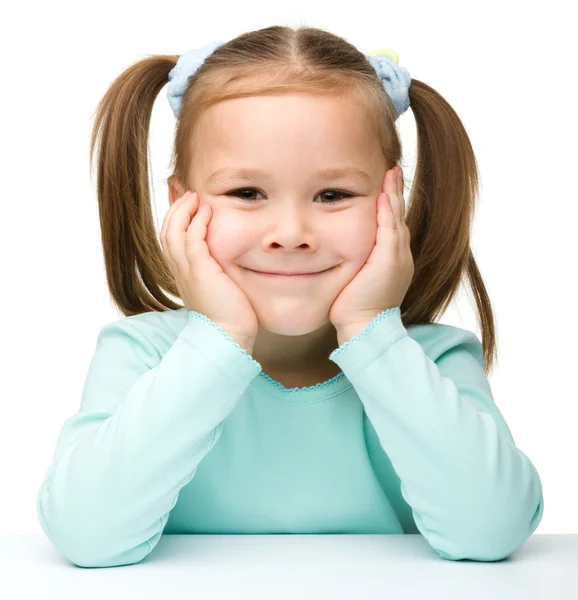 Šťastná holčička sedí u stolu a úsměv — Stock fotografie