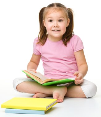 Cute little girl reads a book clipart