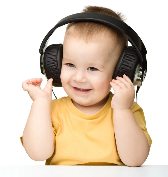可爱的小男孩，享受音乐使用头戴式耳机 — 图库照片