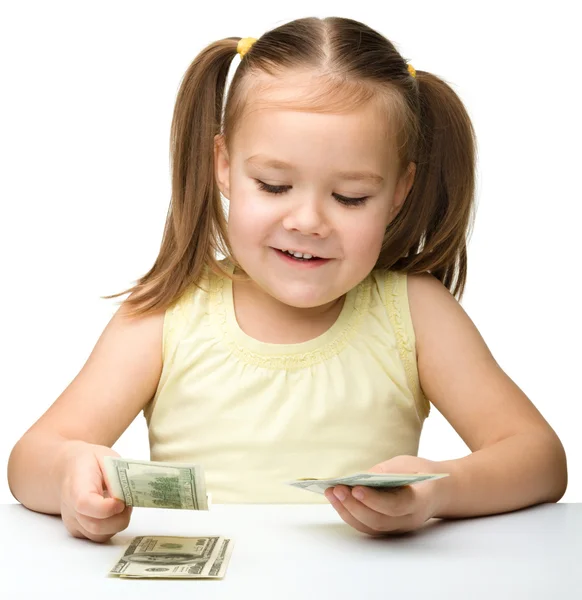 Cute cheerful little girl is counting dollars — Stock Photo, Image