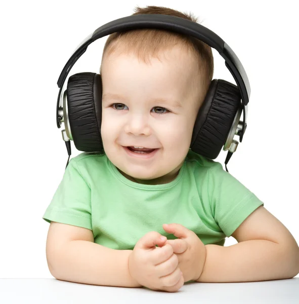 Lindo niño disfrutando de la música usando auriculares —  Fotos de Stock