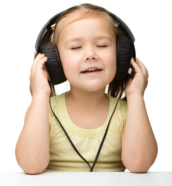 Schattig klein meisje genieten van muziek met behulp van hoofdtelefoon — Stockfoto