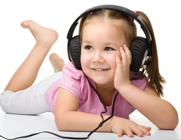 stock image Cute little girl enjoying music using headphones