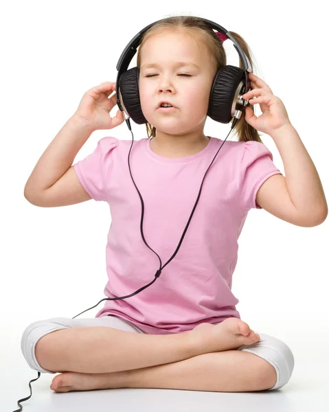 Schattig klein meisje genieten van muziek met behulp van hoofdtelefoon — Stockfoto