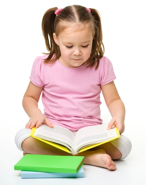 Søt liten jente leser en bok. – stockfoto