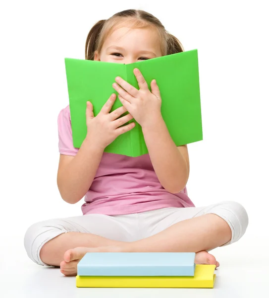 可爱的小女孩躲在一本书后面 — 图库照片