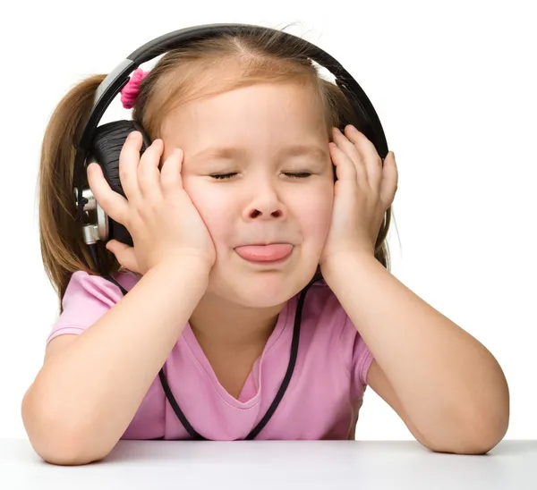 stock image Cute little girl enjoying music using headphones