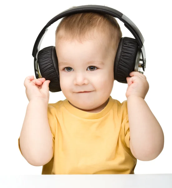 Милый мальчик наслаждается музыкой в наушниках — стоковое фото
