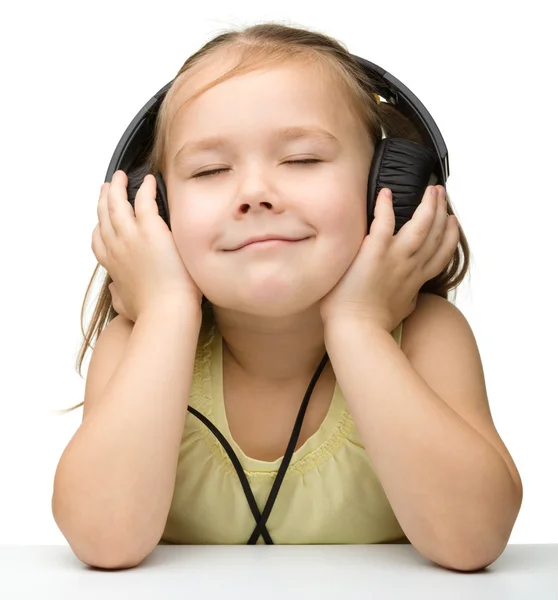 Nettes kleines Mädchen genießt Musik mit Kopfhörern — Stockfoto