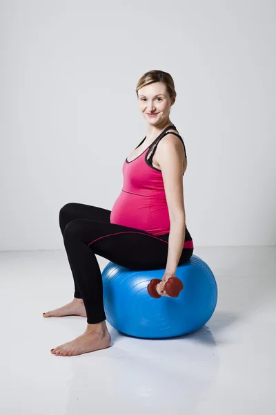 Těhotná žena cvičení s činkami — Stock fotografie