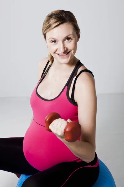 Těhotná žena cvičení s činkami — Stock fotografie