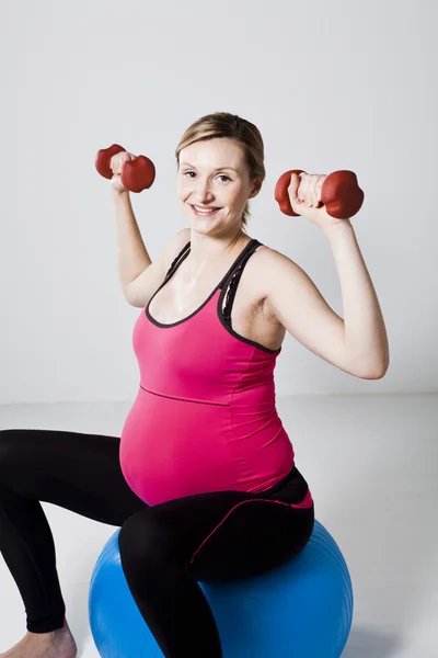 Pregnant woman exercising with dumbbells — Stock Photo, Image