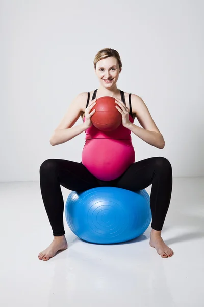Беременная женщина, упражняющаяся с мячом — стоковое фото