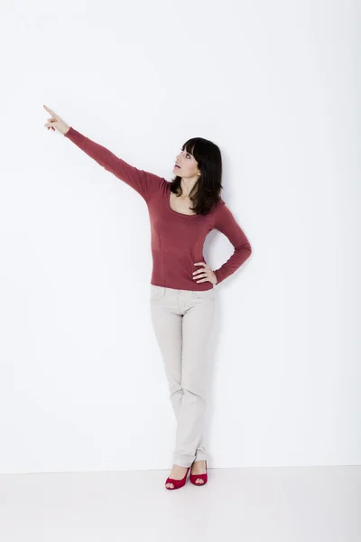 Mulher bonita de pé e apontando — Fotografia de Stock