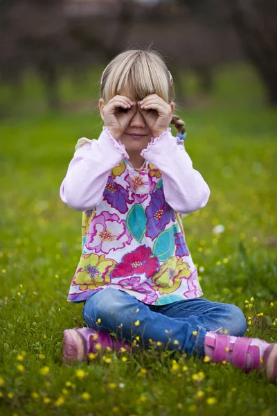 Liten flicka utomhus med imaginära kikare — Stockfoto