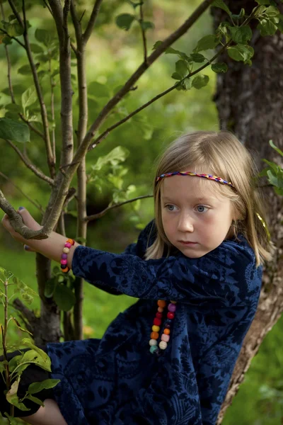 Petite fille assise sur une branche d'un pommier — Photo