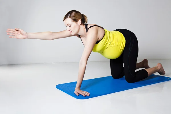 Mulher grávida se exercitando no tapete — Fotografia de Stock