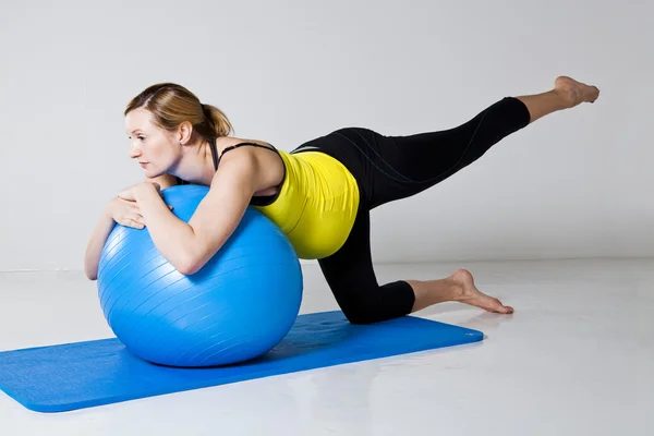 Těhotná žena cvičení s fitness míč — Stock fotografie