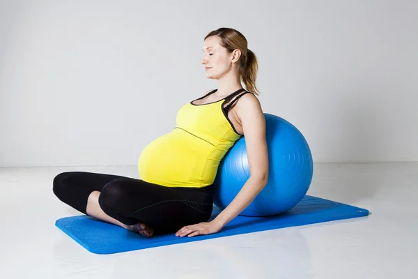 Těhotná žena relaxační proti fitness míč — Stock fotografie