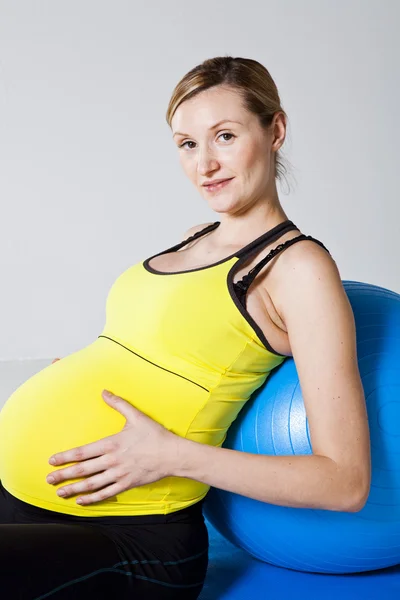 Gravid kvinna avkopplande mot fitness boll — Stockfoto
