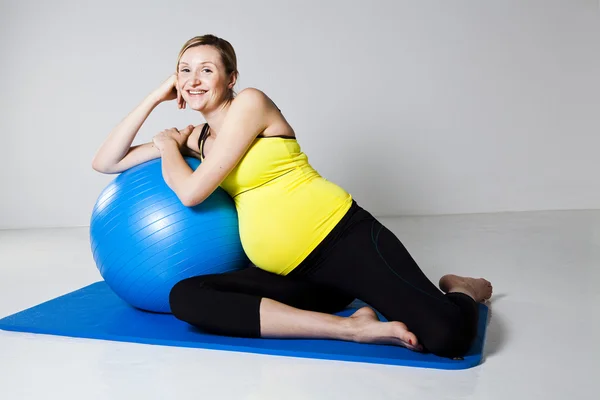 Mulher grávida relaxando contra bola de fitness — Fotografia de Stock