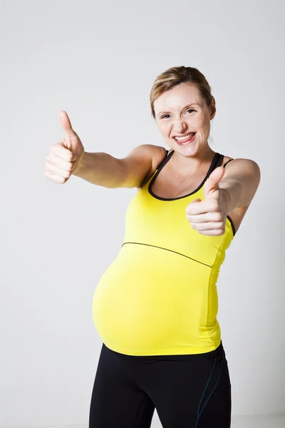 Беременная женщина делает большие пальцы вверх — стоковое фото