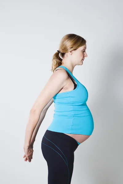 Mujer embarazada estiramiento — Foto de Stock