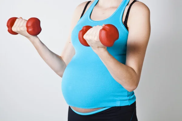 Donna incinta che si esercita con i manubri — Foto Stock