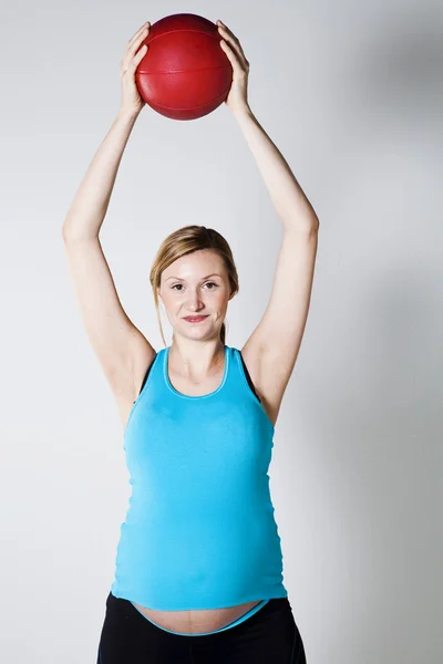 Těhotná žena cvičení s míčem — Stock fotografie