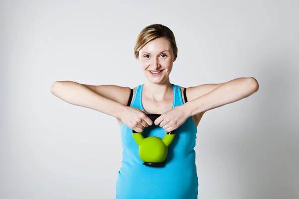 Těhotná žena cvičení s kettlebell — Stock fotografie
