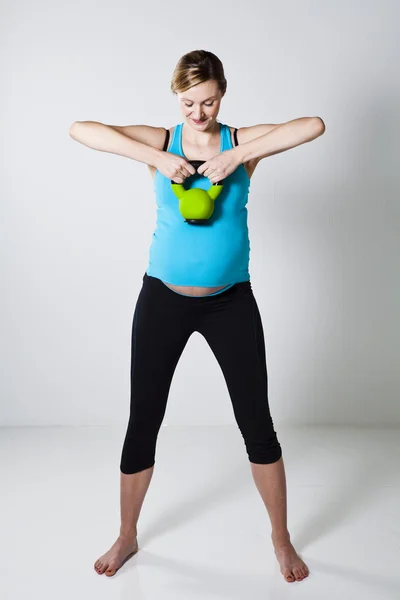 Mujer embarazada haciendo ejercicio con kettlebell —  Fotos de Stock