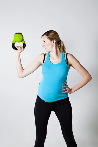 Беременная женщина занимается гиревым гирями — стоковое фото
