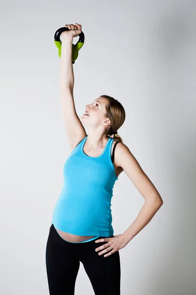 Pregnant woman exercising with kettlebell — Stock Photo, Image
