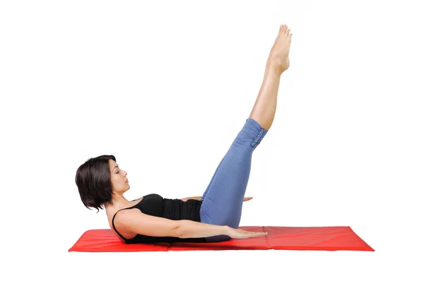 Ajuste o instrutor de pilates fêmea jovem que mostra exercícios diferentes em um fundo branco — Fotografia de Stock