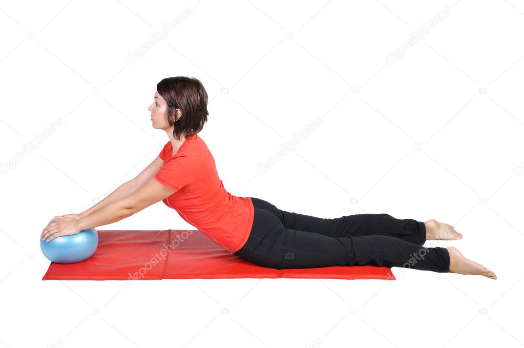Fit young female pilates instructor showing different exercises with ball on a white background
