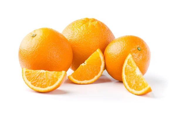 Три апельсина и ломтики на белом фоне — стоковое фото