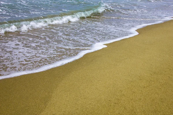 stock image Sea wave on golden beach sand in sunset