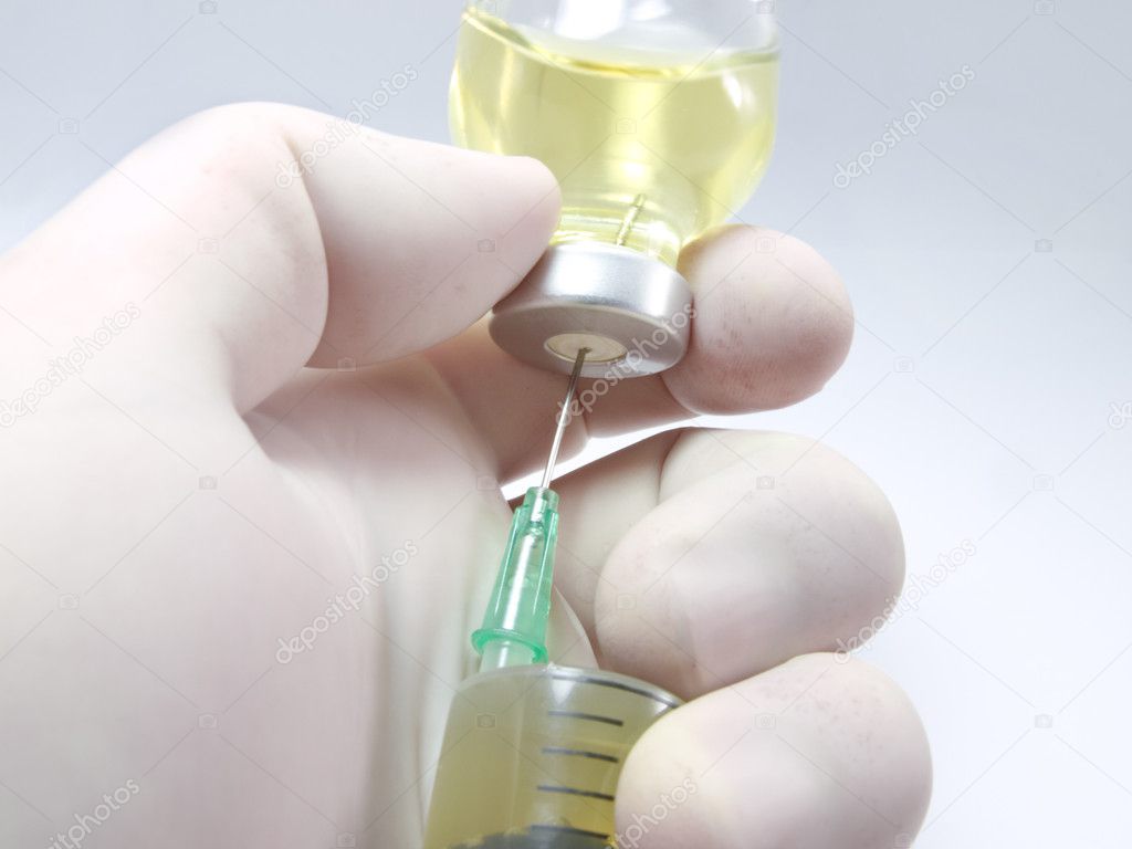 Hand, a syringe and vial