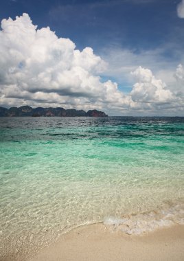 Clear sea water and blue sky with clouds clipart