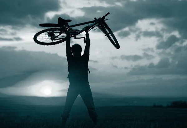 Mann mit Fahrrad angehoben — Stockfoto