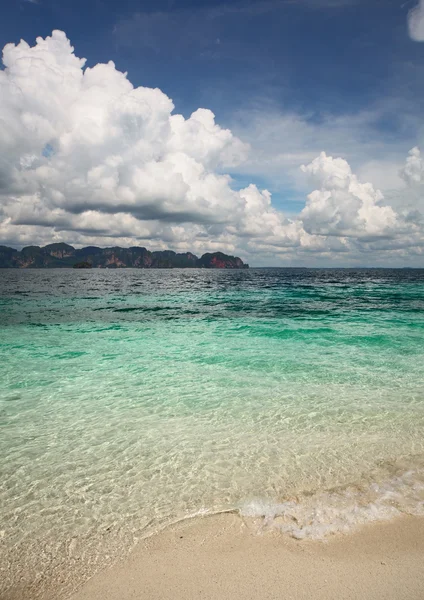 Água do mar límpida e céu azul com nuvens — Fotografia de Stock